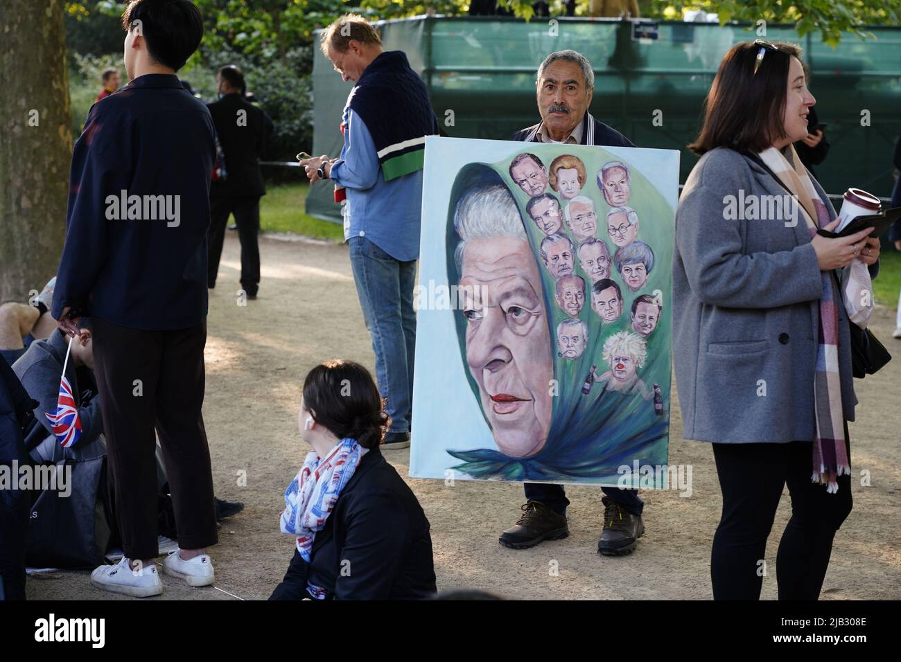 London, UK. 2nd June, 2022. During The Queen's Platinum Jubilee Celebrations, a man holds a painting showing the Queen and the 14 Prime Ministers that she has worked with. The Mall, London, UK. Credit: Grant Rooney/Alamy Live News Stock Photo