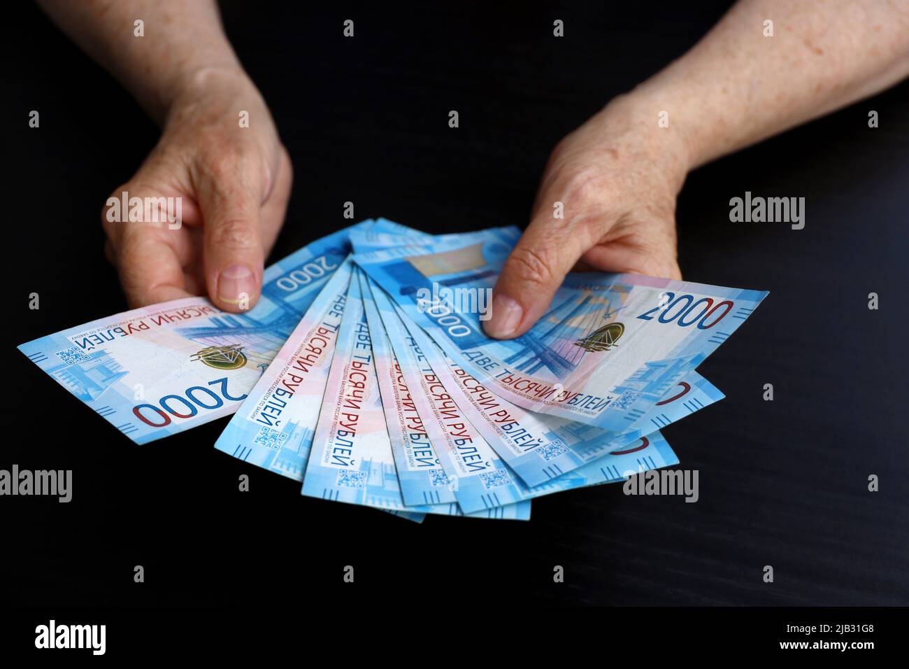Russian rubles in wrinkled hands of elderly woman. Concept of pension increase in Russia, retired payments Stock Photo