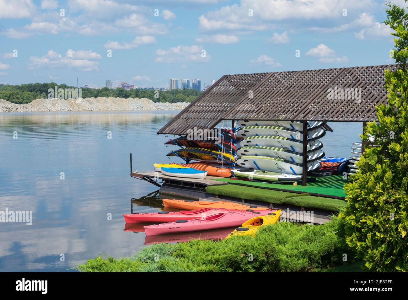 Ukraine, Dnipro, July 2021. Bright colored kayak from plastic boats in the yacht club. Active summer vacation on the water on a bright sunny day. Stock Photo