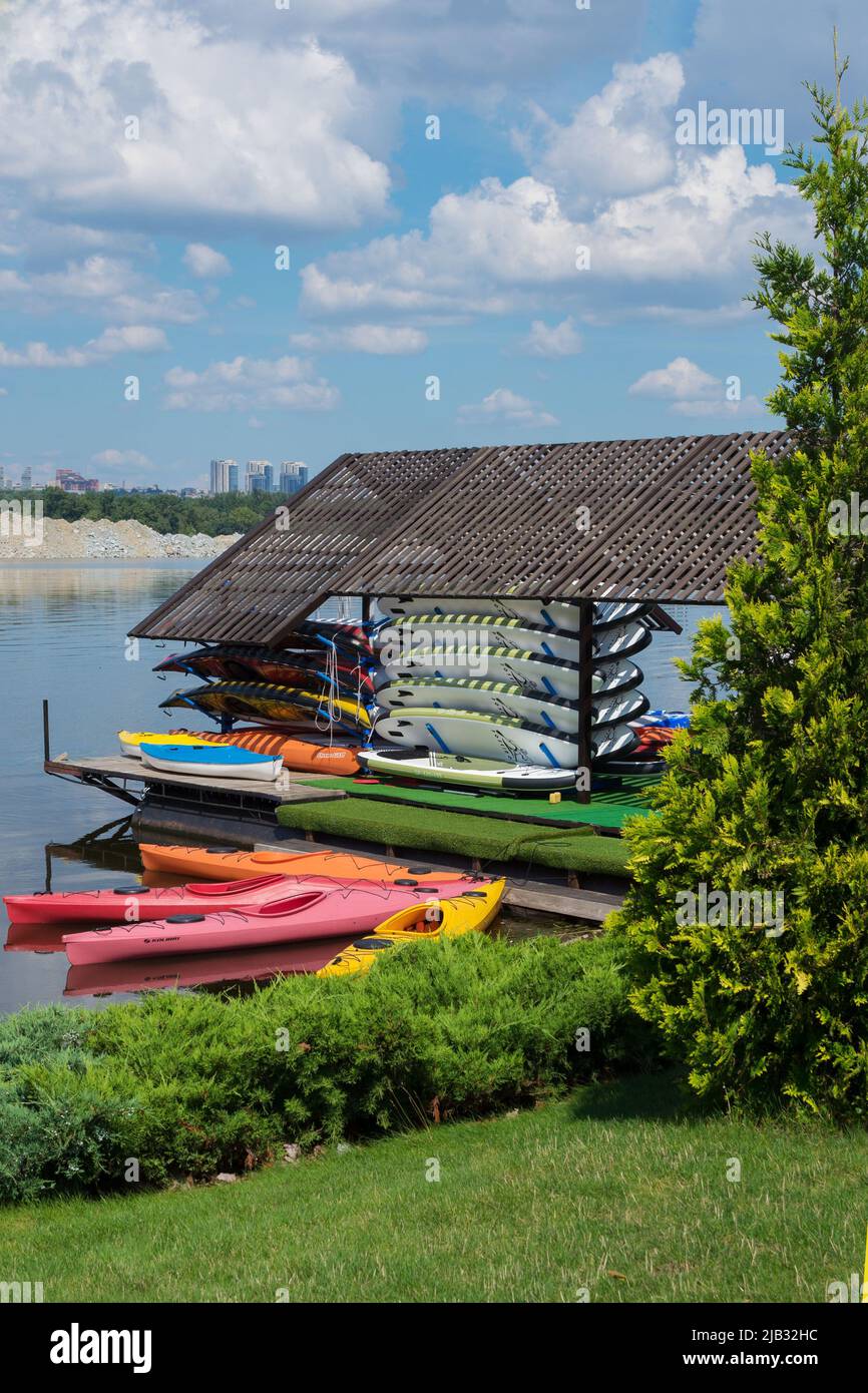 Ukraine, Dnipro, July 2021. Bright colored kayak from plastic boats in the yacht club. Active summer vacation on the water on a bright sunny day. Stock Photo