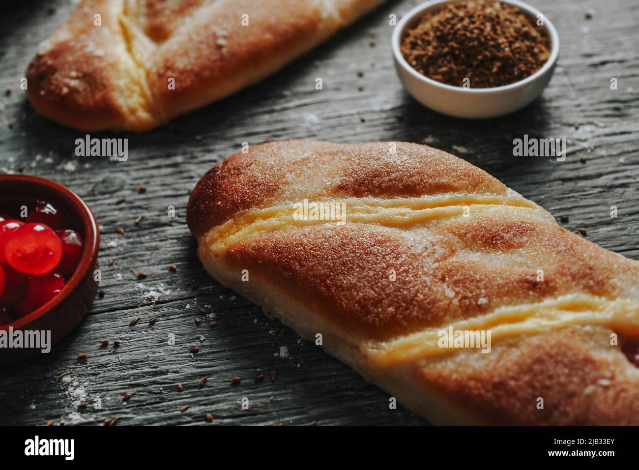 closeup of some catalan coca de sant joan, a sweet flat cake from catalonia, spain, eaten on saint johns eve, on a gray rustic wooden table next to a Stock Photo