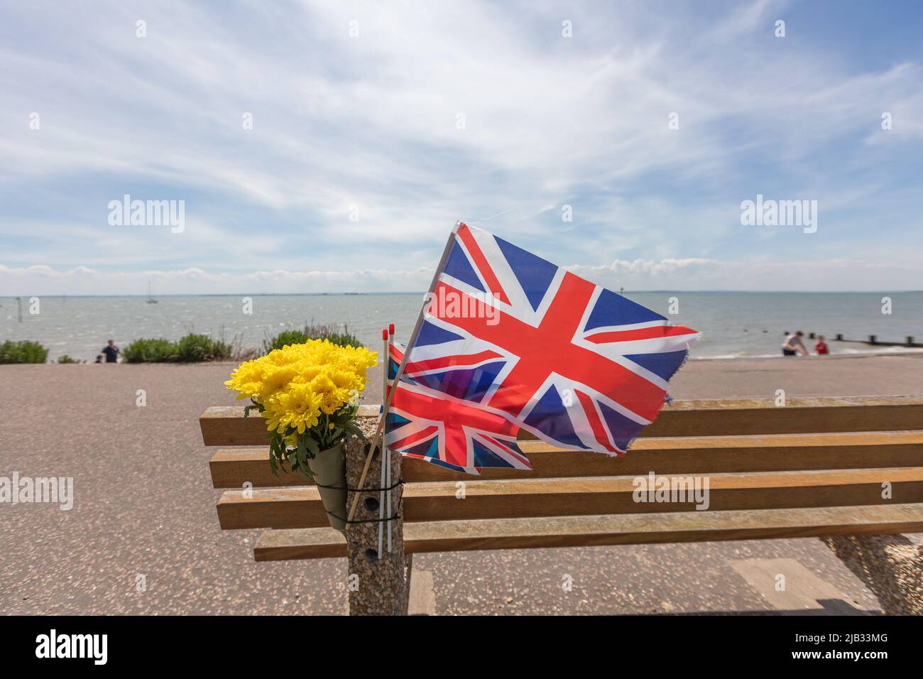 Southend on sea, UK. 2nd June, 2022. Flags and flowers on a memorial bench on the seafront. Scenes around Southend on Sea as people celebrate the Queens Platinum Jubilee and the bank holiday. Penelope Barritt/Alamy Live News Stock Photo