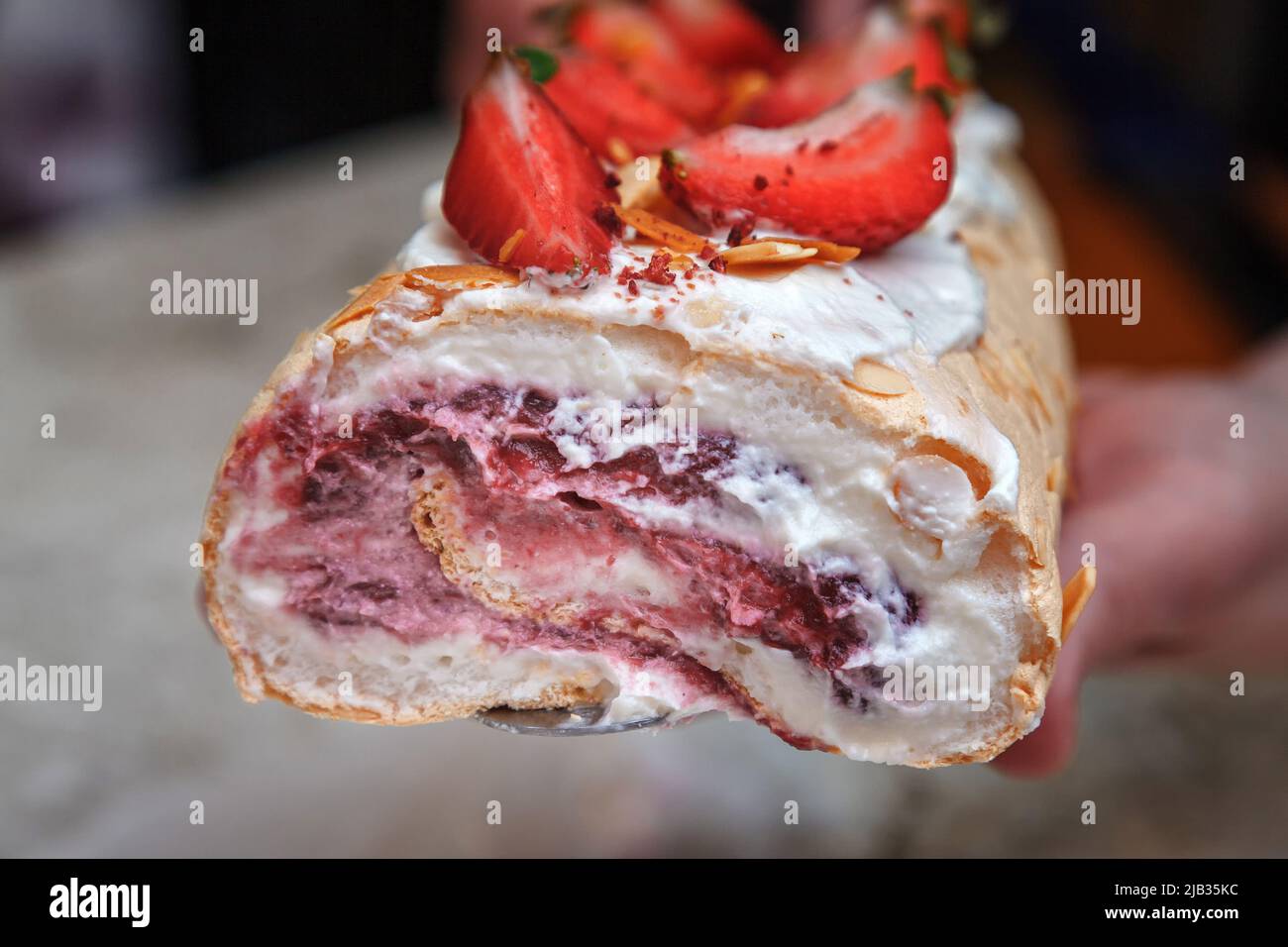 Meringue roll decorated with creamy cream and slices of fresh ...