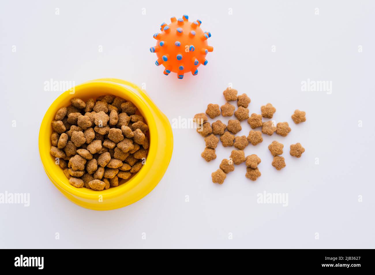 top view of dry and crunchy pet food near bowl and rubber toy isolated on white Stock Photo