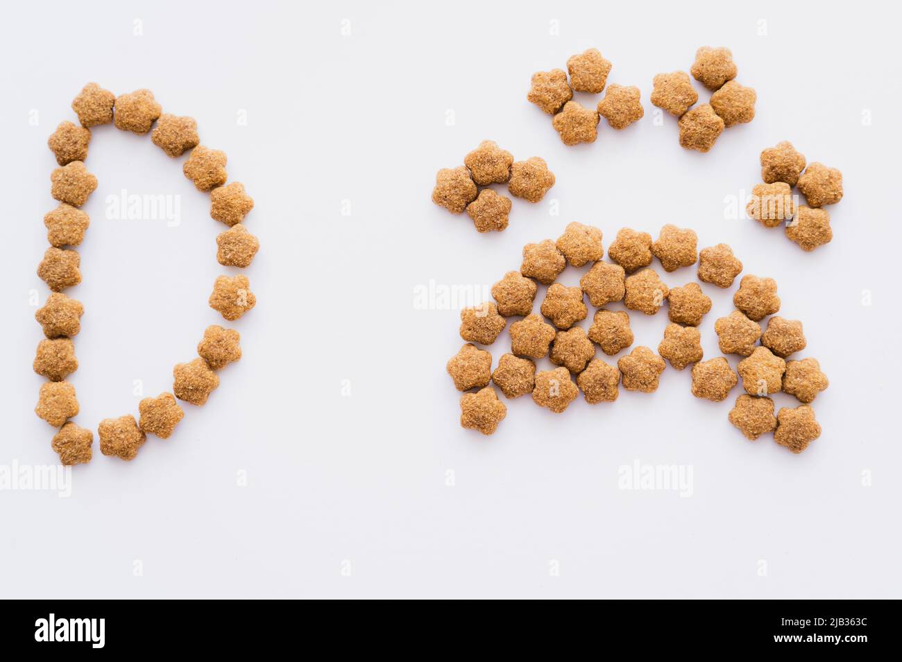 top view of paw shape made of dry pet food near letter isolated on white Stock Photo
