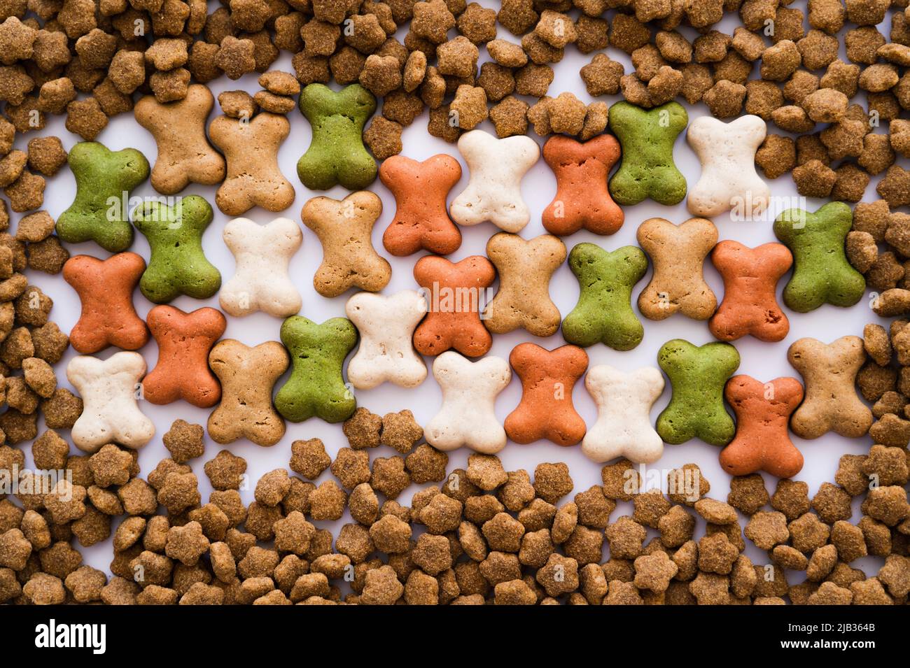 top view of bone shaped cookies and dry pet food as backdrop Stock Photo