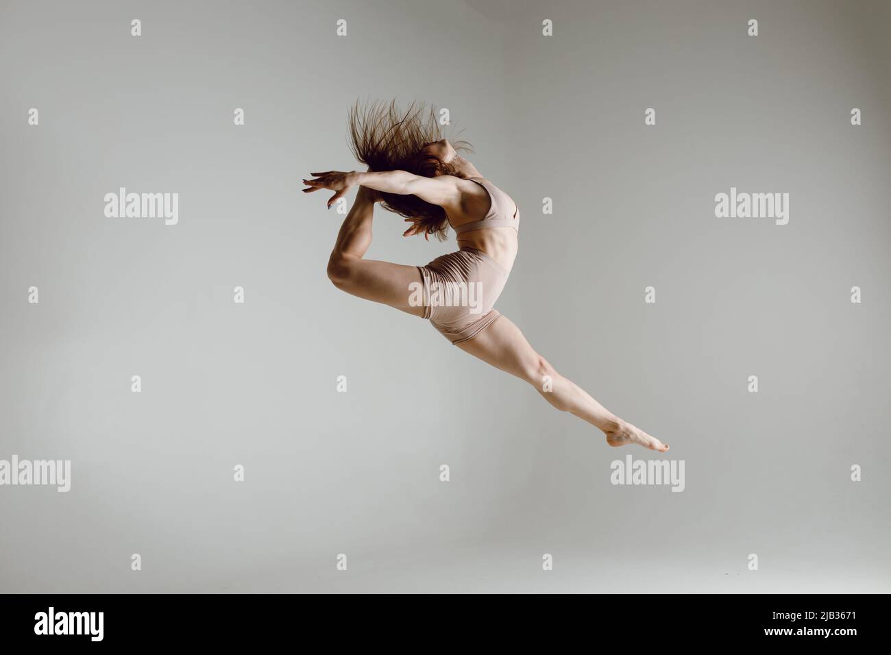 Young woman contemporary ballet dancer dancing high heels dance jumping leg split ballerina Stock Photo