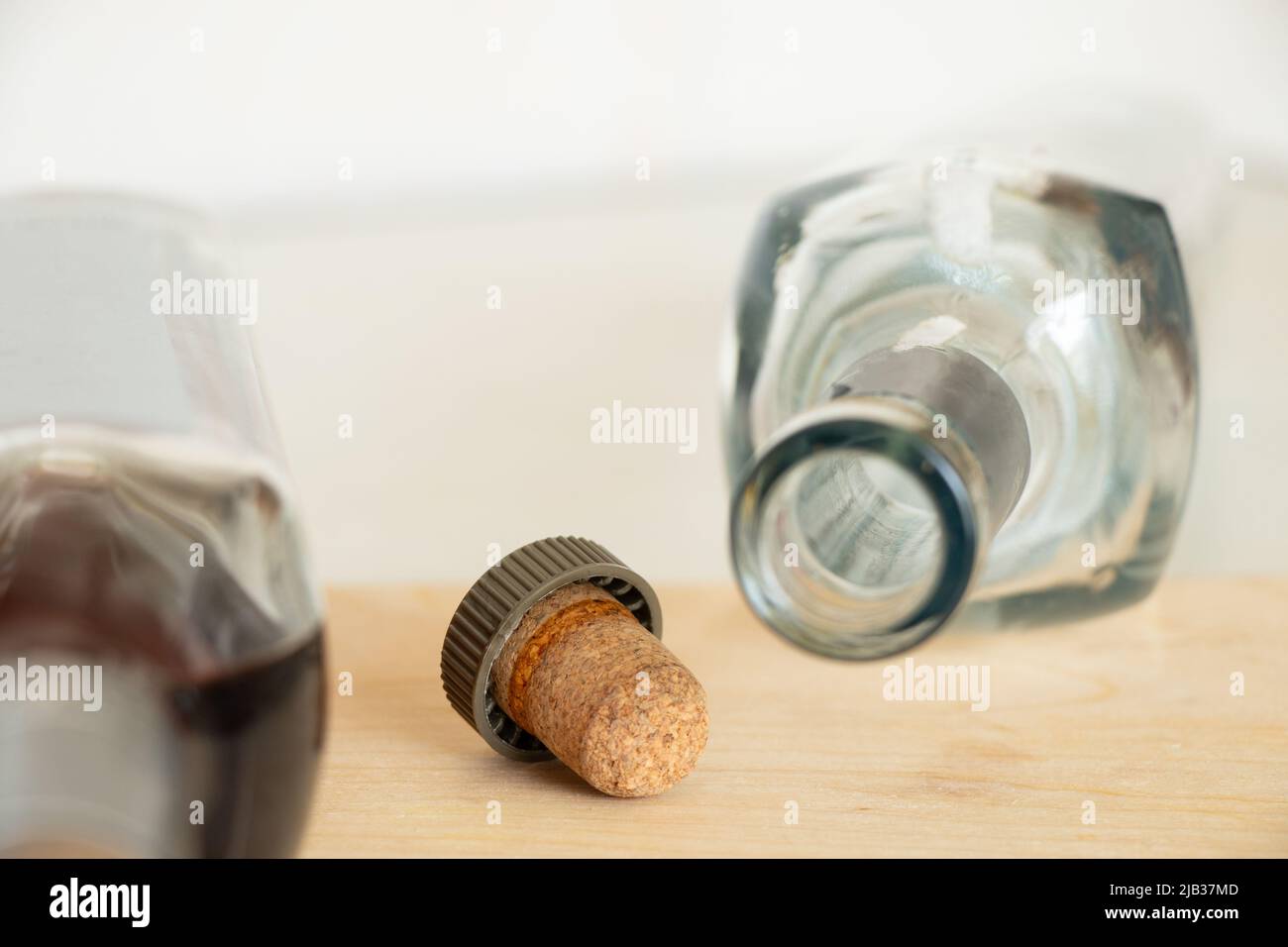 Two bottles, one full one empty with cognac and a cork on the table in the kitchen, alcohol on the table at home, a bottle of cognac Stock Photo