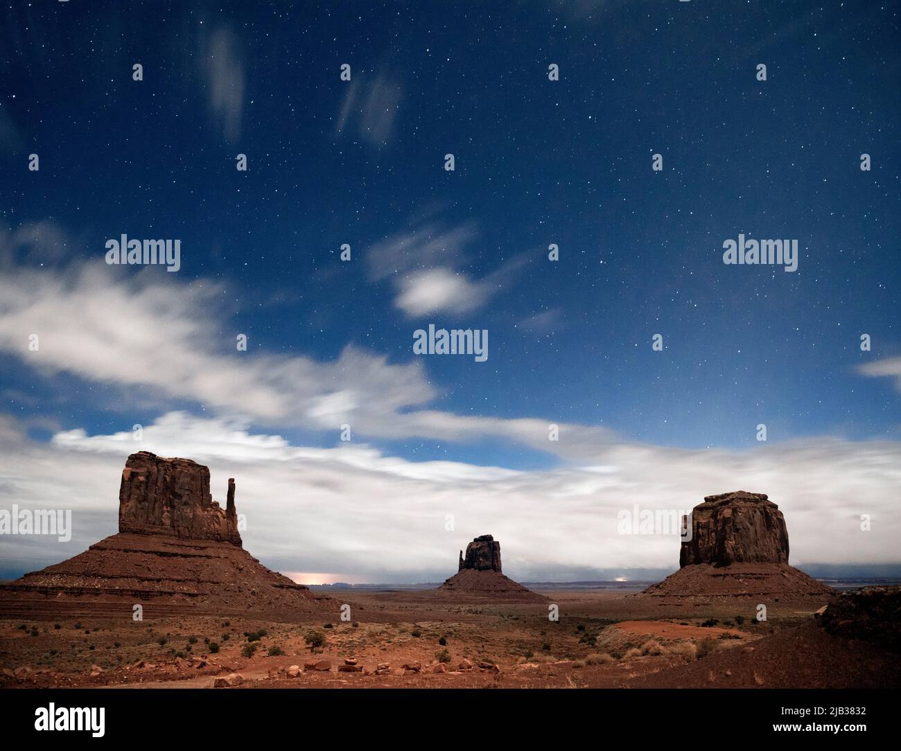 AZ00438-00....ARIZONA - Stars and clouds over West Mitten Butte, East Mitten Butte and Merrick Butte in Monument Valley Navajo Tribal Park. Stock Photo