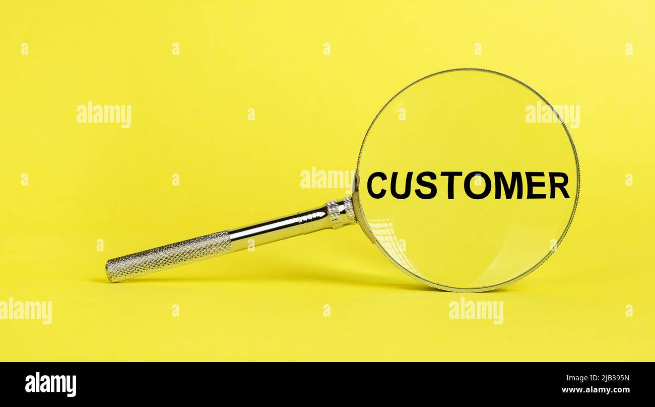 Magnifying glass with word customer on yellow background. Exploring clients, consumers attitudes, needs, behaviors. Marketing concept. High quality photo Stock Photo