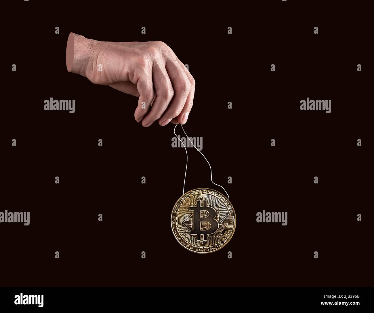 Hand holding bitcoin coin by strings. Manipulation in cryptocurrency  exchanges, spoofing. Frauds with digital money. Controlling or artificially  affecting price. High quality photo Stock Photo - Alamy