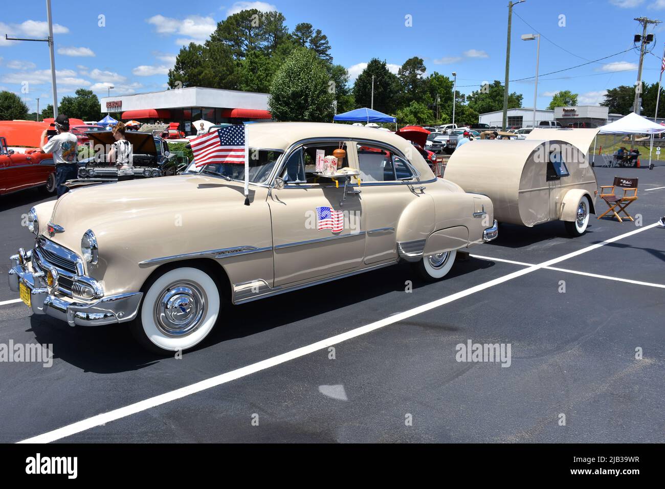 A 1951 Chevrolet Deluxe pulling a 1948 Tear Drop Camper on display at a car show. Stock Photo