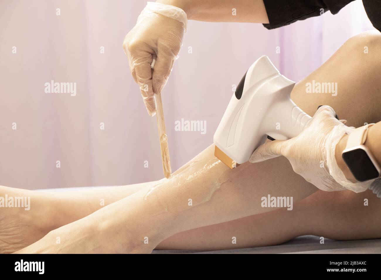 removal of hair with a laser device from a girl's leg in a beauty salon, Aparati for laser treatment hair removal from a girl's body Stock Photo