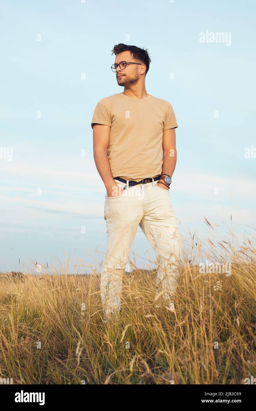 Portrait of a young man fashion model outdoors in the field Stock Photo