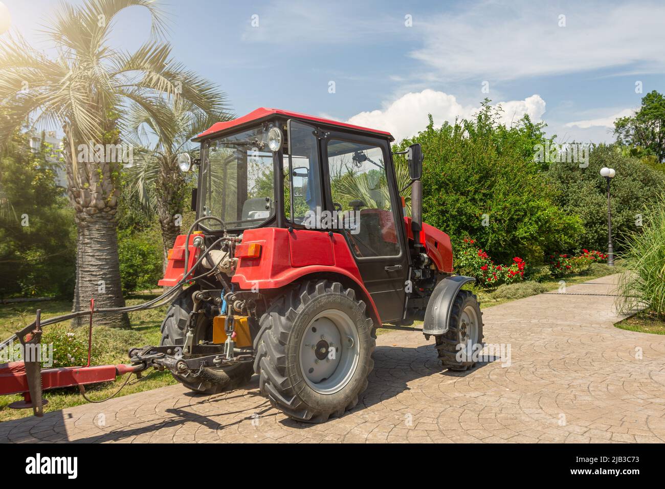 Red tractor in the city park, maintenance service of the territory Stock Photo