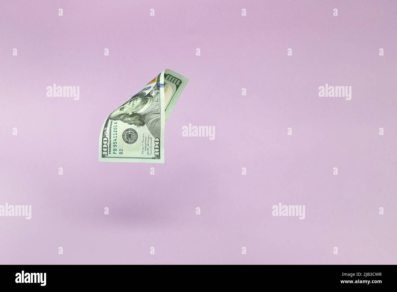 100 Dollar banknotes flying on pink background. Economy, savings and the US dollar. One hundred American dollars. 100 Stock Photo