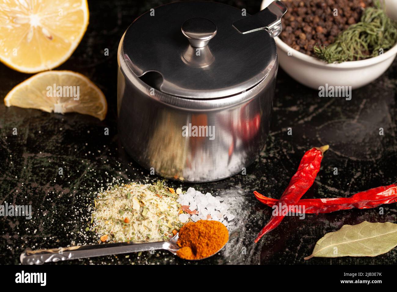 Metal container for spices with assortment of spices for cooking on a