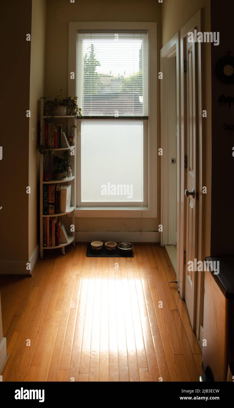 Morning sunlight coming in through blinds in kitchen hallway Stock Photo