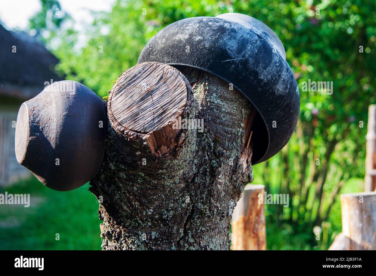Traditional East Slavic Thick-walled pan for cooking in a Dutch oven cast-iron boiler hanging on the fence Stock Photo
