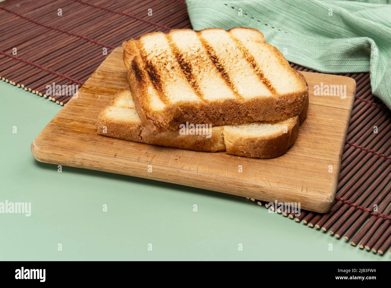 loaf of bread toast on top of wooden board and green background Stock ...