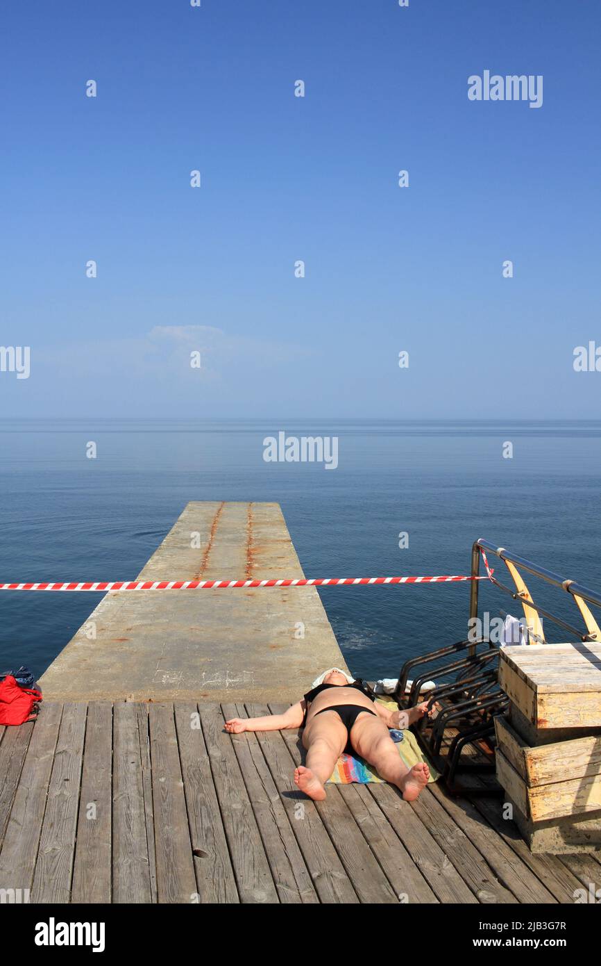 Odessa, Ukraine. 01st June, 2022. A woman sunbathing on the promenade