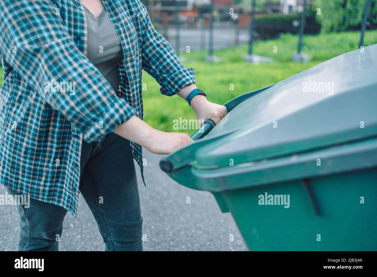 European 20s girl take out the trash can sorting garbage near a home Stock Photo