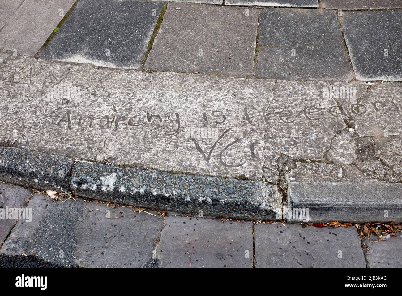 'Anarchy is Freedom' Message written in wet cement on roadside pavement in Penarth South Wales Stock Photo