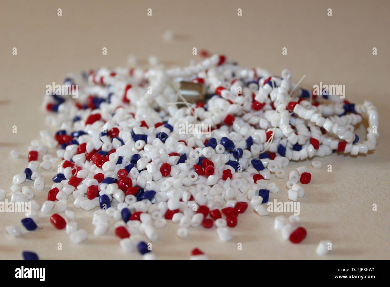 Scattered beads on the table, torn jewelry for repair Stock Photo