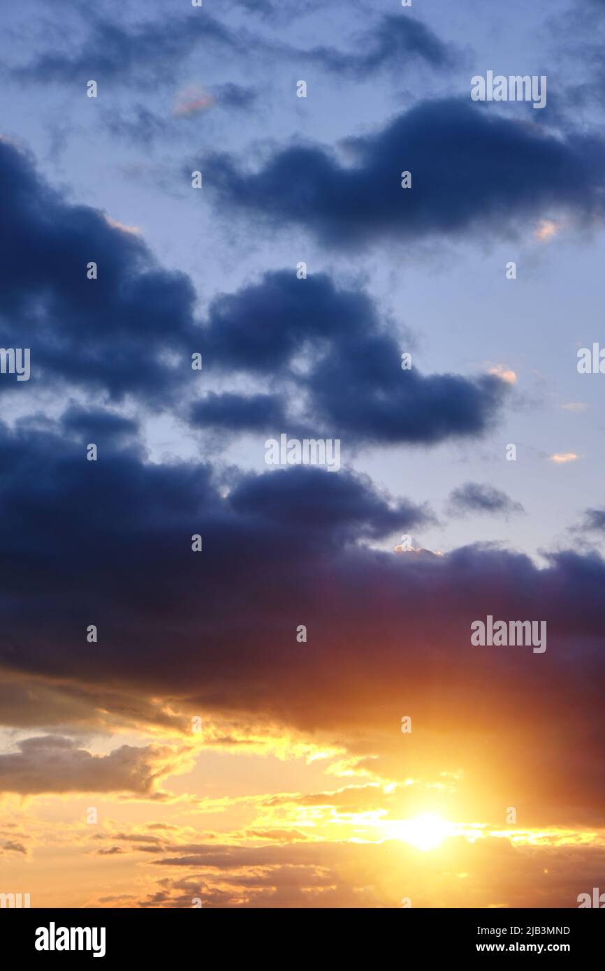 Thunderclouds with breaking rays sun at sunset Stock Photo