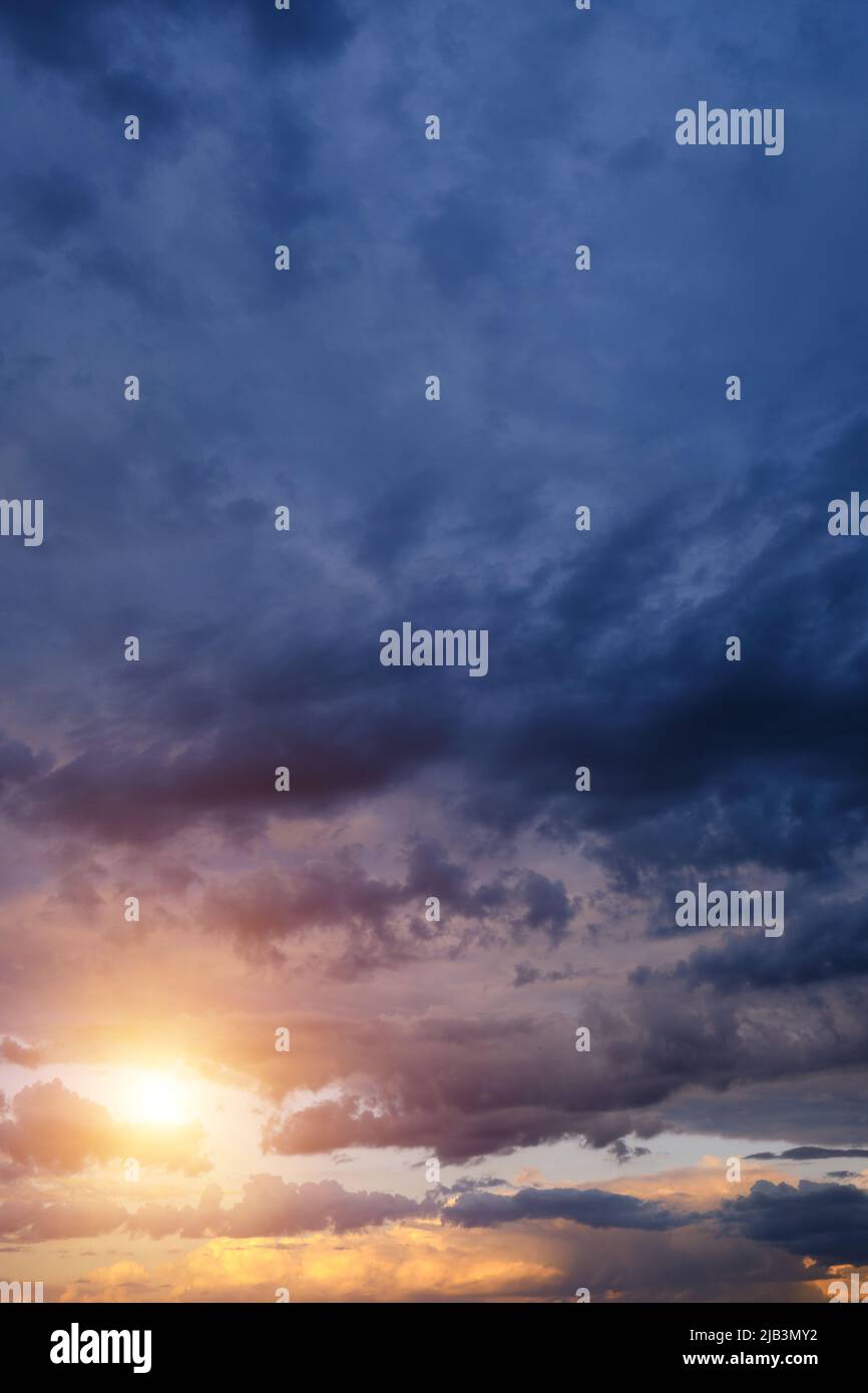 Thunderclouds with breaking rays sun at sunset Stock Photo