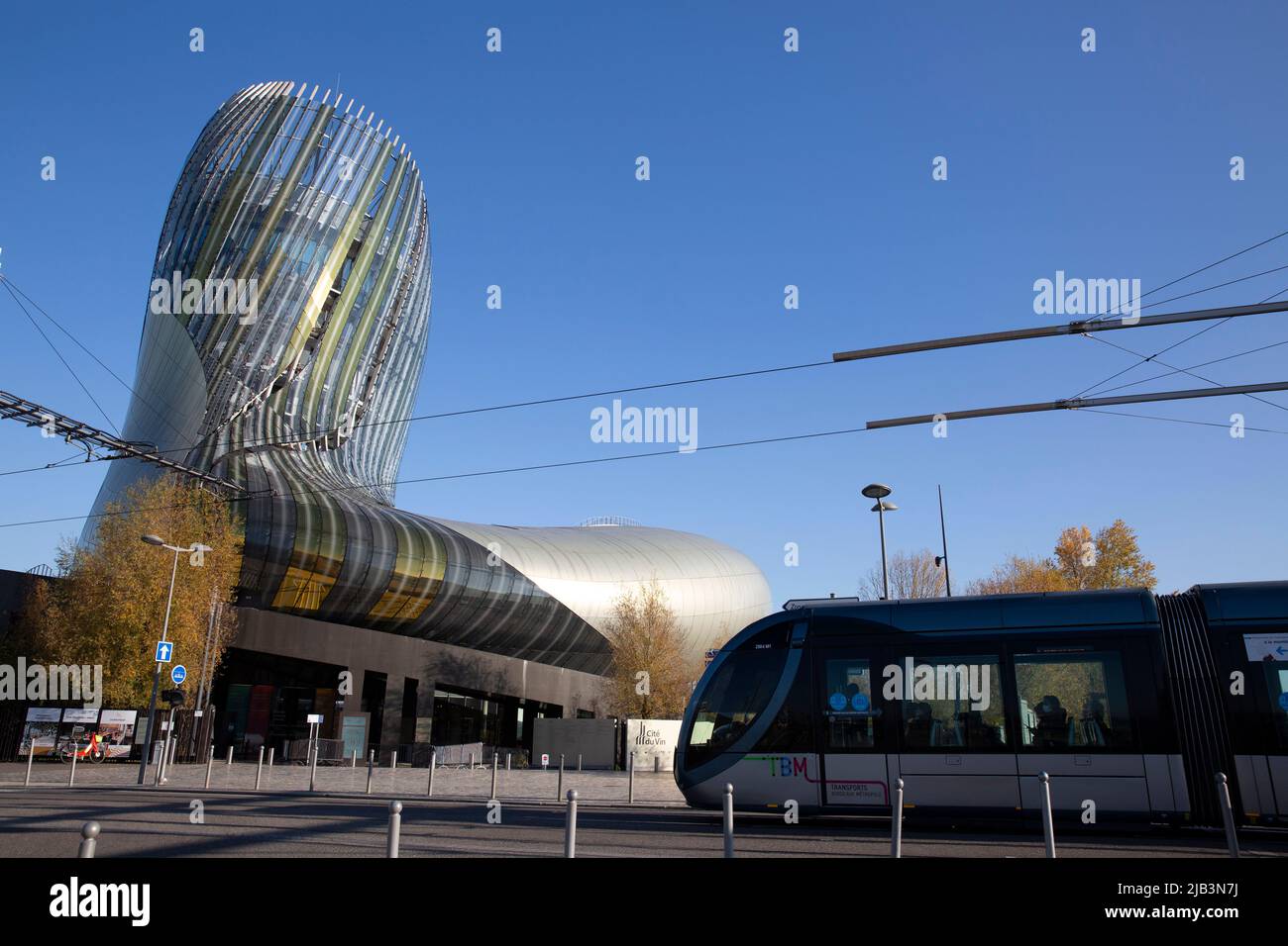The Cité du Vin and the tram in Bordeaux, France on November 19, 2021. The Cité du Vin was inaugurated in 2016 with the goal of celebrating wine and educating people about its production and history. The 13,350 m² space is considered to be the best wine center in the world. It's been designed by the French architectural company, XTU, with the exhibitions designed by the British firm Casson Mann. Photograph by Bénédicte Desrus Stock Photo