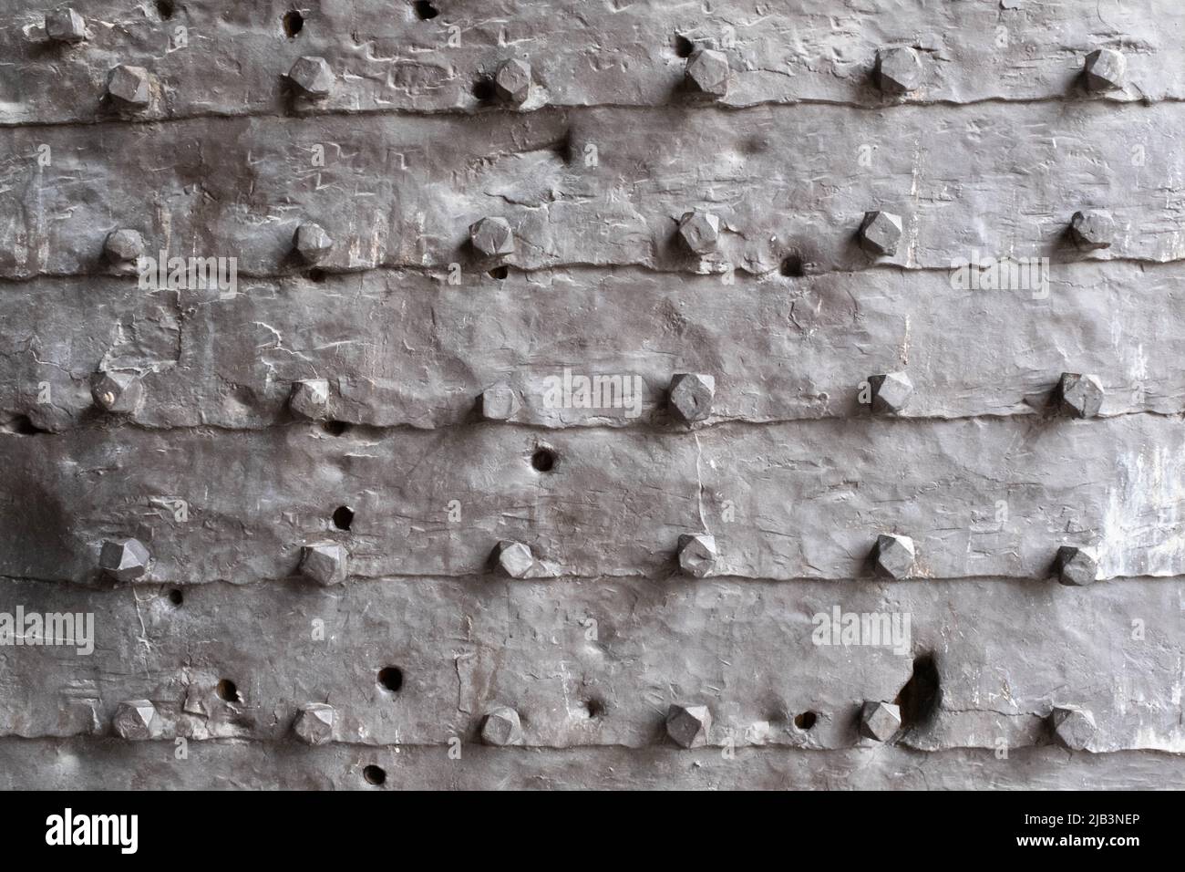 Texture of the iron space, close-up. Background of metal surface from sheets with rivets. A metal relief backing for branding, calendar, postcard Stock Photo