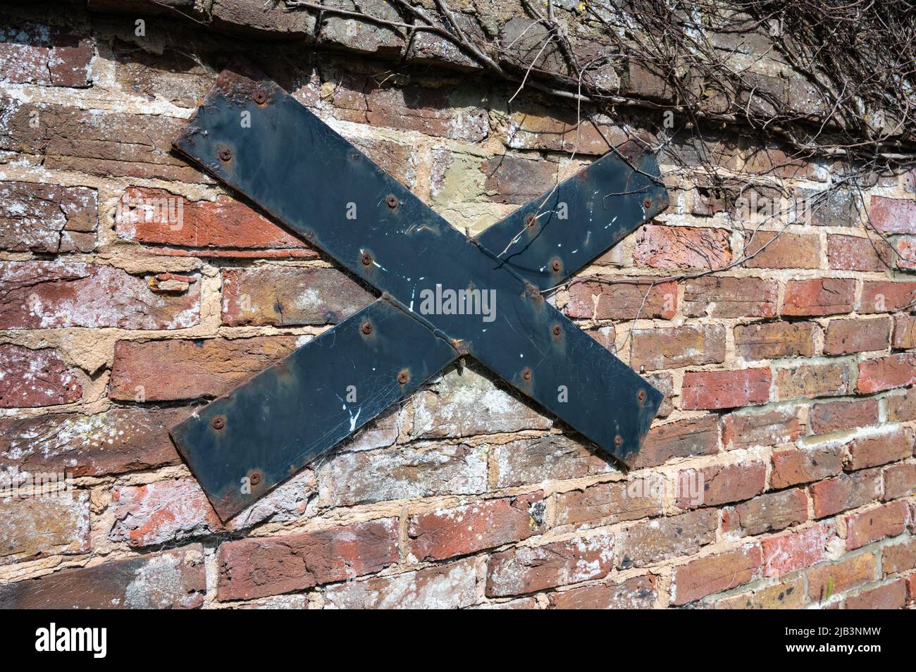 Pattress Plate or wall tie bar on a wall to secure and strengthen an unstable or weak outside brick wall, in the UK. Stock Photo