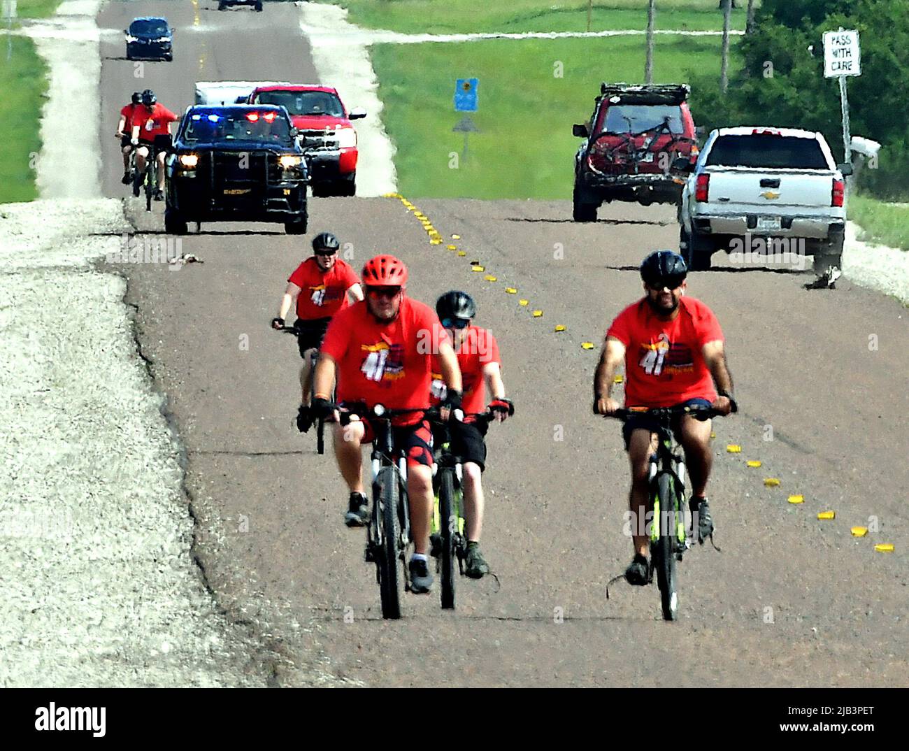 EMPORIA, KANSAS - JUNE 2, 2022 Local police officers and sheriffs deputies riding bicycles escort the Flame of Hope for Special Olympics south along state route 99 outside of Emporia on the way 90 miles south to Wichita during the Kansas Law Enforcement Torch Run to raise awareness and funds to benefit the organization Stock Photo