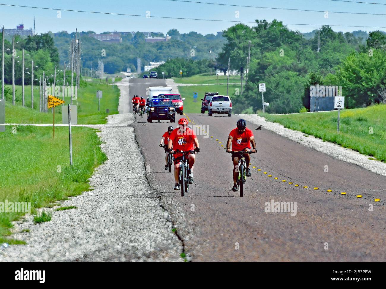 EMPORIA, KANSAS - JUNE 2, 2022 Local police officers and sheriffs deputies riding bicycles escort the Flame of Hope for Special Olympics south along state route 99 outside of Emporia on the way 90 miles south to Wichita during the Kansas Law Enforcement Torch Run to raise awareness and funds to benefit the organization Stock Photo