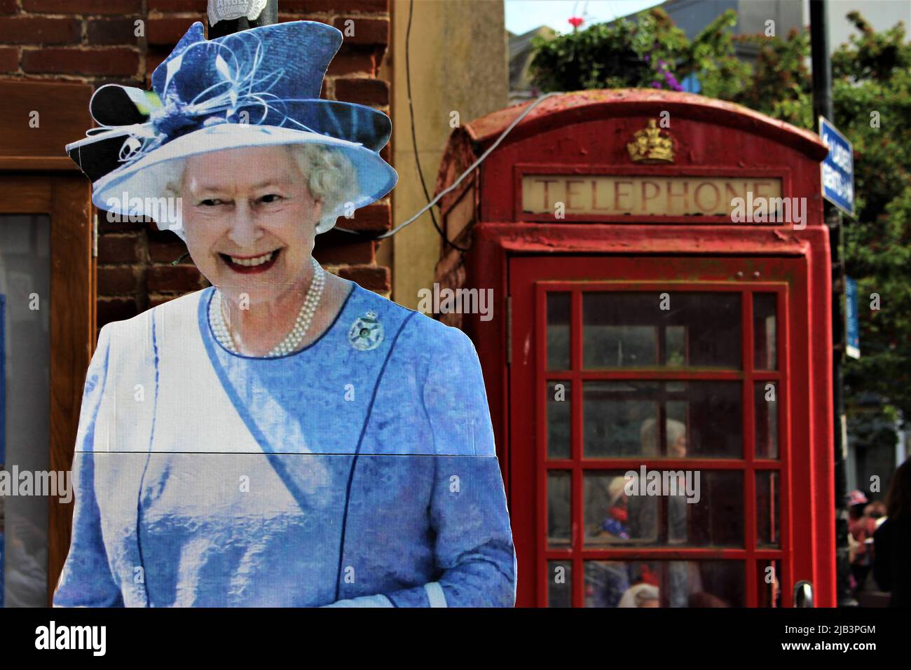 Cut out of Elizabeth II in front of an old telephone booth. Decorations like these were put up to celebrate the Queen's Platinum Jubilee across the UK Stock Photo