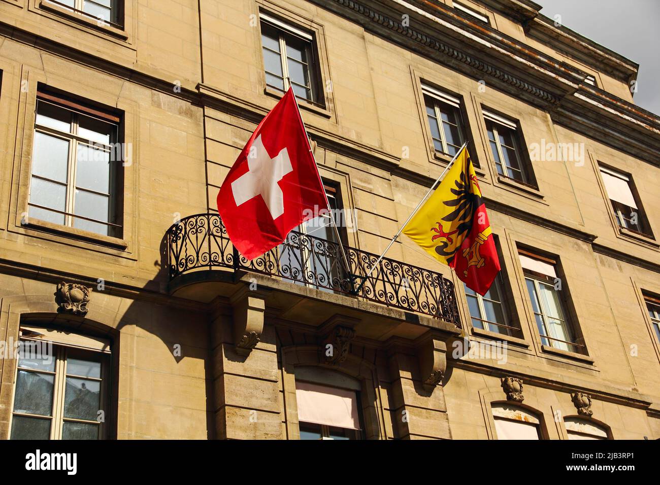 Flags of Switzerland and of the Canton of Geneva on the front of the municipal building. Stock Photo