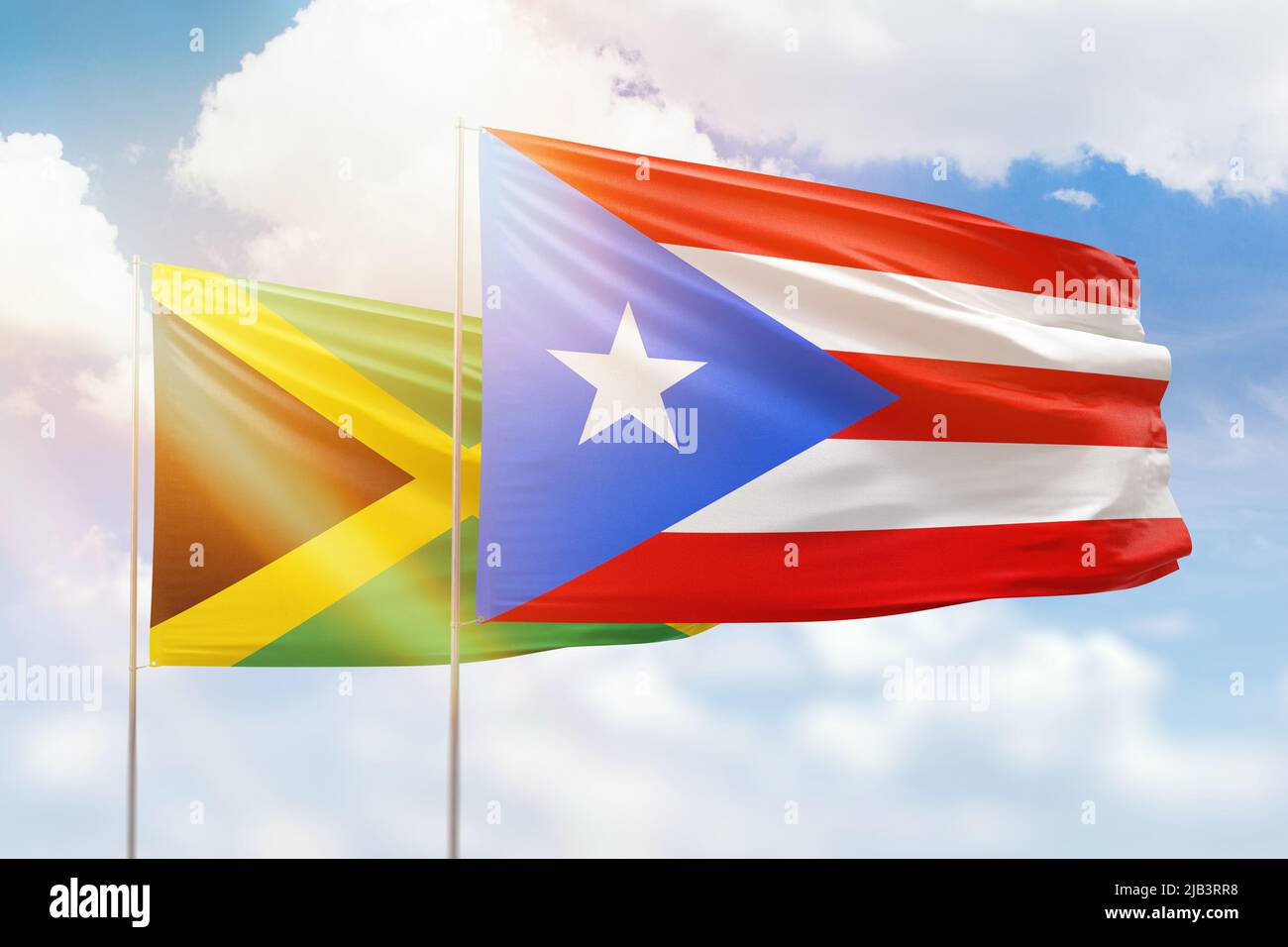 Sunny blue sky and flags of puerto rico and jamaica Stock Photo - Alamy