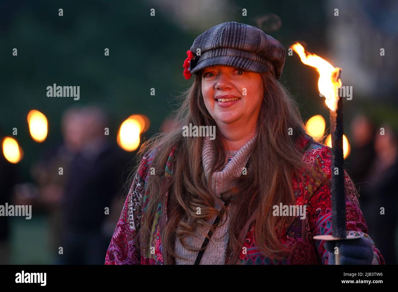 A torchbearer after lighting a Platinum Jubilee beacon on the Queen's