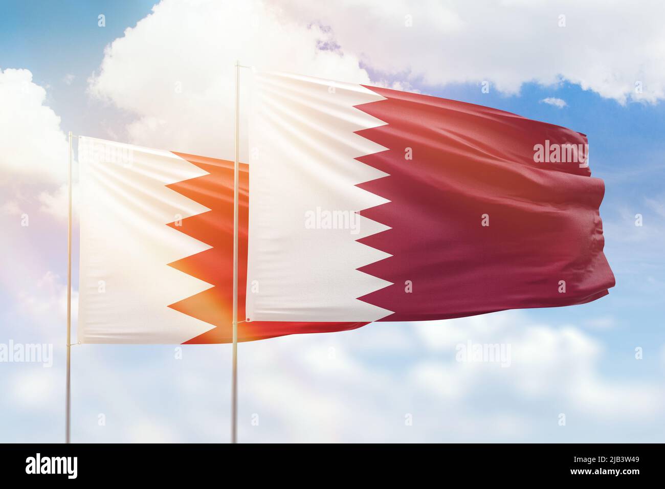 Sunny blue sky and flags of qatar and bahrain Stock Photo