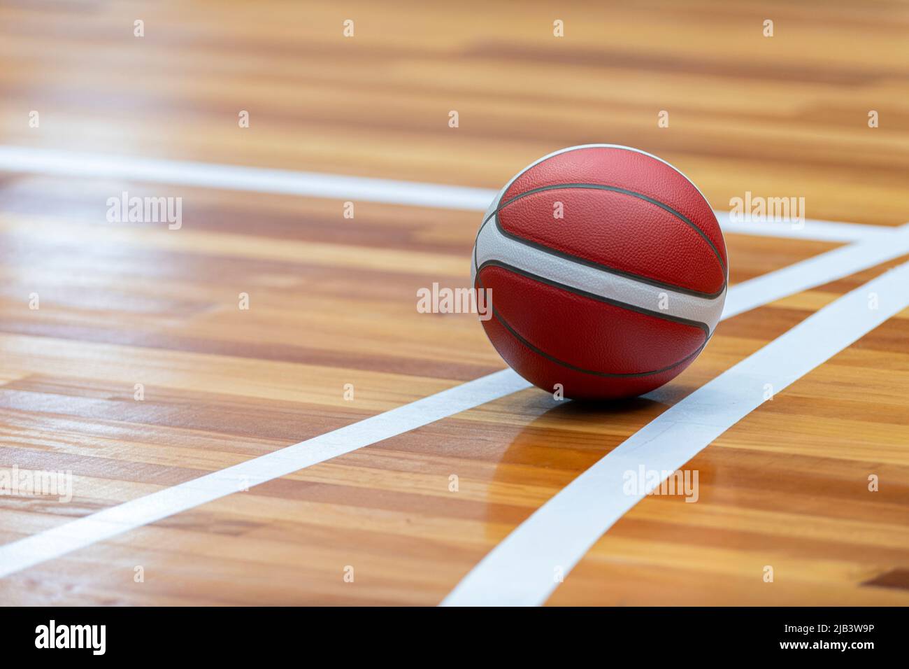 Basketball court wooden floor with professional orange leather ball and shadows. Horizontal sport poster, greeting cards, headers, website Stock Photo