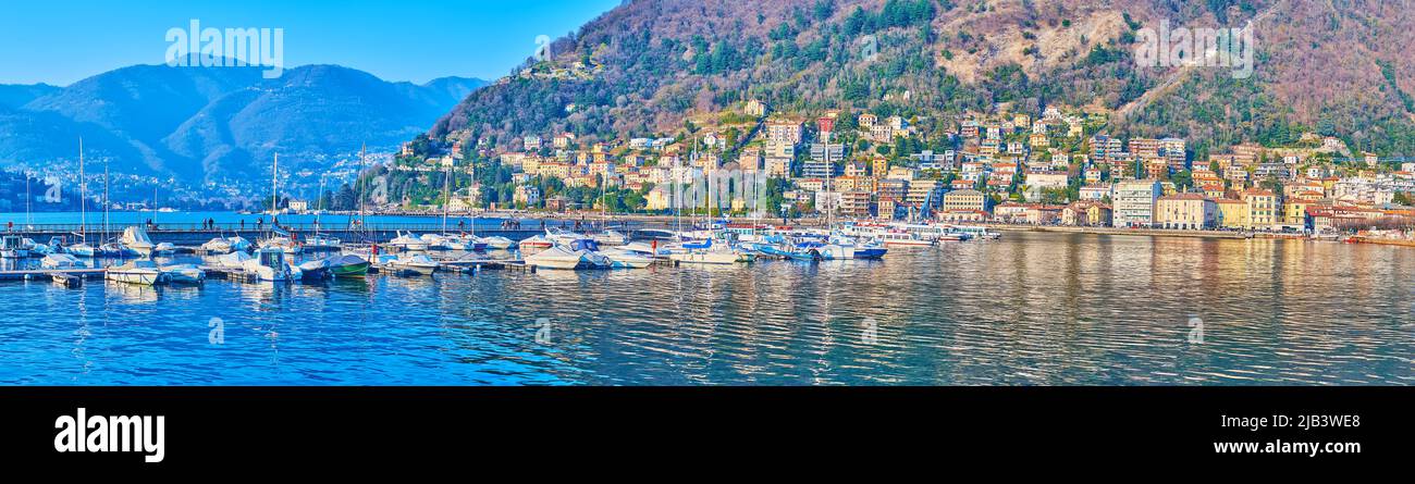 Panorama of picturesque Lake Como, boats, moored at the pier and Monte Boletto with its reflection on water surface, Como, Lombardy, Italy Stock Photo