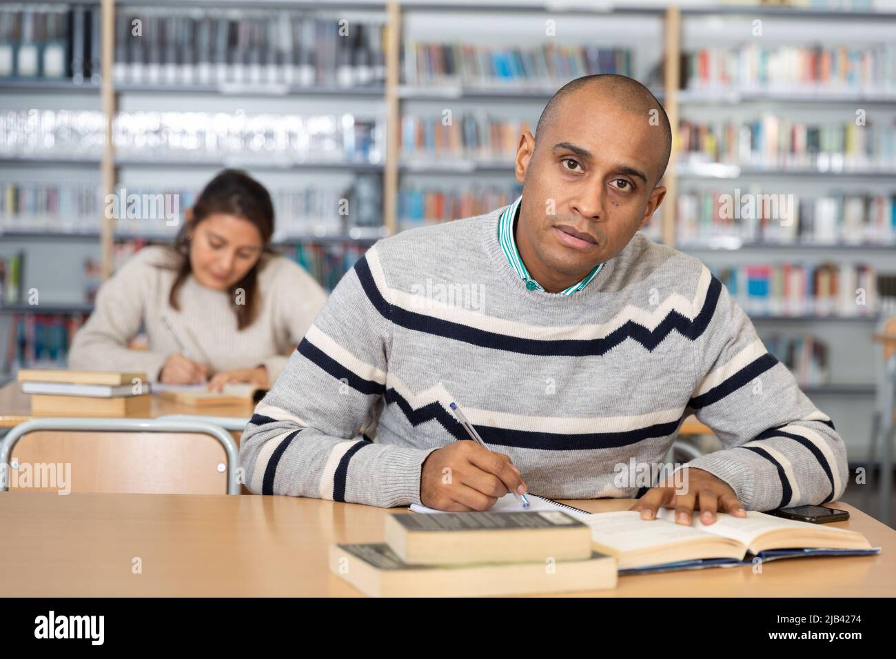 Young adult man studying in public library Stock Photo