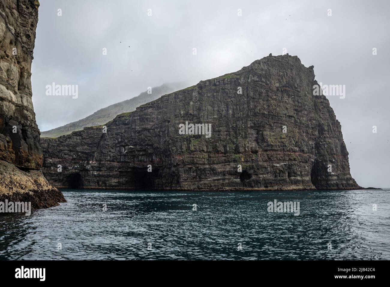Steep cliffs in front of Drangarnir rock formation on Vagar Island seen ...