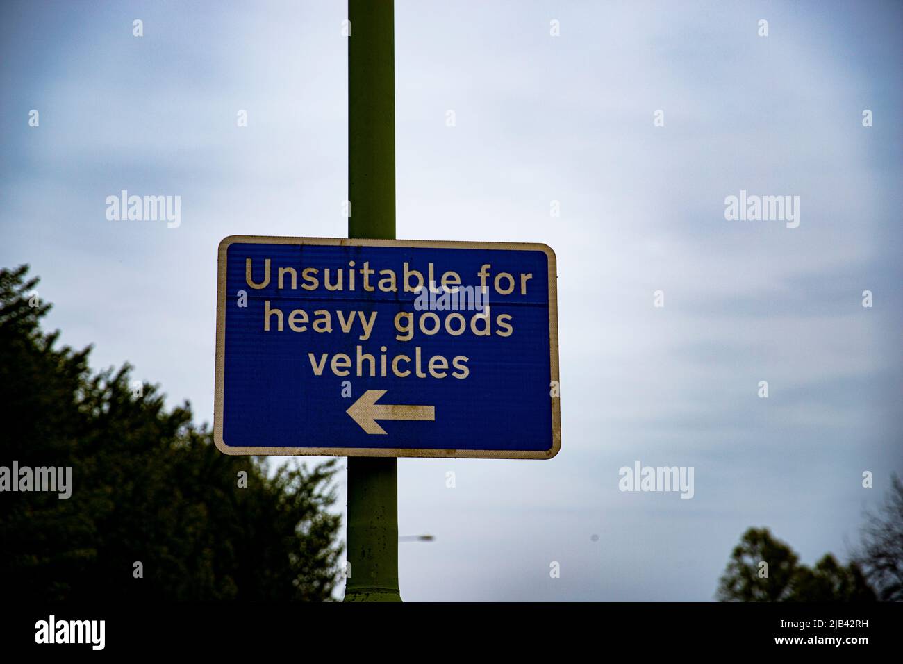 This image of a unsuitable for heavy goods vehicle signs shows its bold blue of the sign itself, amongst its eerie moody sky and background. Stock Photo