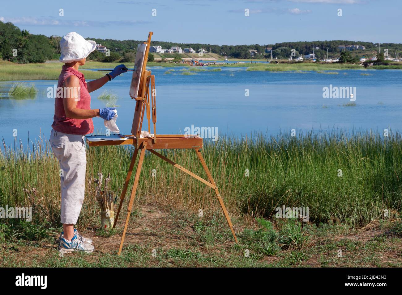 Female artist painting the scenic Duck Creek on Cape Cod in Wellfleet, Massachusetts, Stock Photo