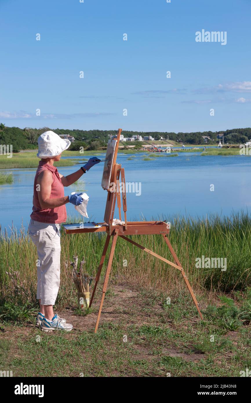 Female artist painting the scenic Duck Creek on Cape Cod in Wellfleet, Massachusetts, Stock Photo