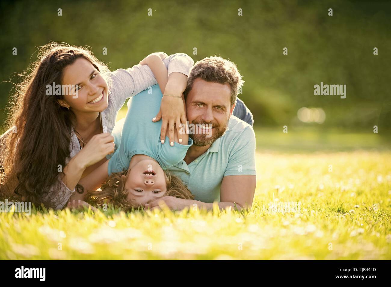 happy family of mom father and son child relax in summer park green grass, family Stock Photo