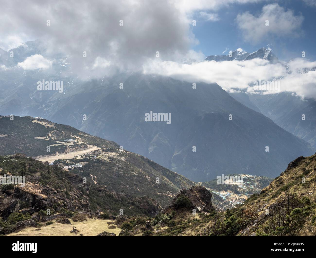 Syangboche airstrip (SYH)  and Namche Bazaar (R) from the 4200m ridge above Khunde. Stock Photo