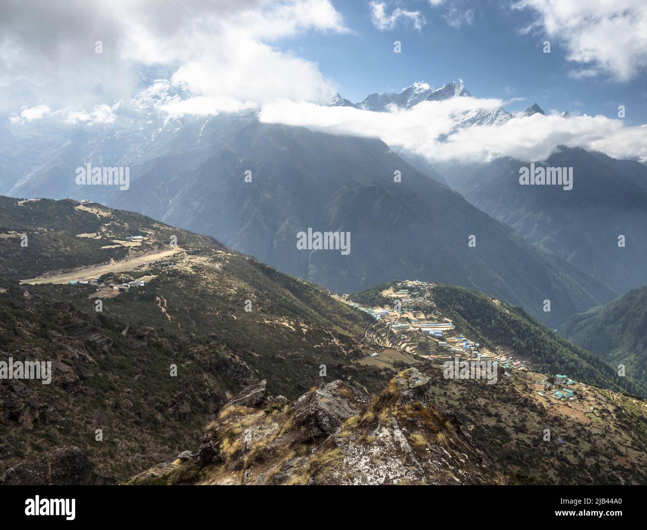 Syangboche airstrip (SYH) (L) and Namche Bazaar (R) seen from the 4200m ridge above Khunde. Stock Photo